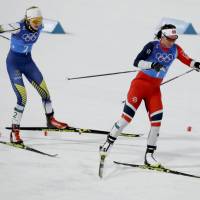 Norway’s Marit Bjoergen (right) and Sweden’s Stina Nilsson compete in the women’s 4×5-km relay cross-country skiing race in Pyeongchang, South Korea on Saturday. Norwegian Marit Bjoergen equals Winter Olympics medals record