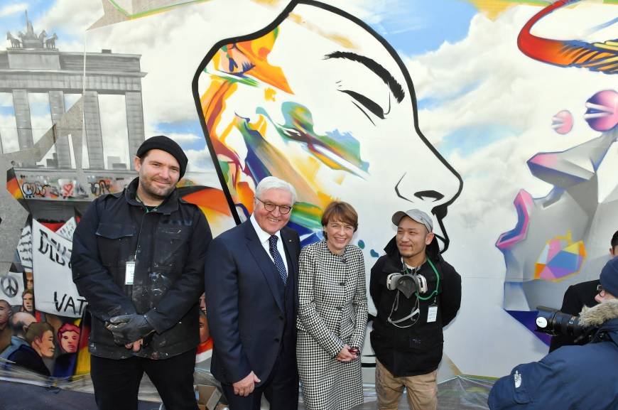 German President Frank-Walter Steinmeier (second from left) and his wife, Elke Büdenbender, pose for a photo alongside graffiti artists Justus Becker (left) and Imaone (right) at the launch of an art project titled 