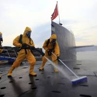 Chinese sailors in protective gear clean and disinfect a nuclear submarine during a drill at the Qingdao submarine base in China’s Shandong province in July 2013. China announces 8.1% defense budget boost from 2017 as Xi pursues 'world-class' force