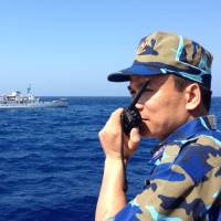 Capt. Nguyen Van Hung of the Vietnamese coast guard speaks to his compatriots by radio as a Chinese coast guard ship cuts across his vessel’s path to prevent access to an oil rig west of the Paracel Islands in the South China Sea in May 2014. Military control of Chinese coast guard adds edge to sea disputes