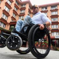 Scott Doolan makes his way along a street in Kathmandu on Thursday. Australian paraplegic aims to be first to reach Everest base camp under own power