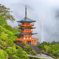 The pagoda of the UNESCO Heritage Seiganto-ji Temple, with the cascading Nachi Falls shrouded in mist in the background, Wakayama Prefecture. Two millennia of heritage along Wakayama's Kumano Kodo trail