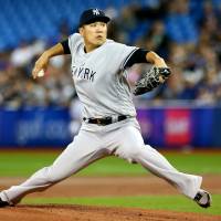 Yankees starter Masahiro Tanaka throws a pitch against the Blue Jays in the first inning on Friday night in Toronto. Yankees star Masahiro Tanaka handcuffs Blue Jays