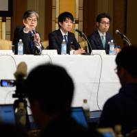 Oki Matsumoto (second from left), president and CEO of Monex Group Inc., takes part in a news conference in Tokyo on Friday. Small cryptocurrency exchanges find the going hard under greater government oversight