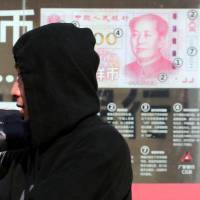 Residents walk past a board highlighting the security markers on the latest yuan note outside a bank in Beijing in November 2016. The Trump administration has once again declined to brand China a currency manipulator, but it did target that country and five others for special monitoring for what the administration says are practices that are worsening America’s trade deficit. U.S. refrains from labeling China a currency manipulator but keeps Japan on list