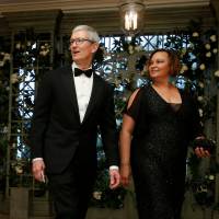 Chief Executive Officer (CEO) of Apple Tim Cook and Lisa Jackson arrive for the State Dinner in honor of French President Emmanuel Macron at the White House in Washington Tuesday. Trade believed key topic as Trump and Apple CEO Tim Cook meet at White House