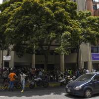 Venezuelan citizens wait outside the Chilean Consulate for information regarding a new visa program in Caracas on Monday. Chile’s new visa for Venezuelans fleeing the country’s economic collapse was greeted by confusion Monday, with hundreds lining up before dawn at the consulate in Caracas worried that they would be barred from entering the country. Venezuelans swarm outside Chilean Consulate seeking new visa and home