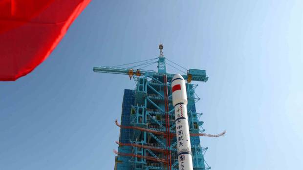People gather to look at China’s Long March 2-F rocket, which later took the Tiangong 1 module into space, as it is rolled out onto a launch platform at the Jiuquan Satellite Launch Center in the northwestern province of Gansu in September 2011. China's 'space dream' sees nation edging closer to manned space station and a lunar landing