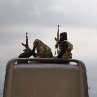 Buses carrying Jaish al-Islam fighters and their families from their former rebel bastion of Douma, arrive at the Abu al-Zindeen checkpoint controlled by Turkish-backed rebel fighters near the northern Syrian town of al-Bab, on Tuesday. Protests erupt in north Syria as pro-Turkey rebels strand Islamist evacuees from Ghouta