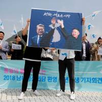 Students hold posters with pictures of South Korean President Moon Jae-in and North Korean leader Kim Jong Un during a pro-unification rally in Seoul on Thursday ahead of the upcoming summit between the North and South. Denuclearization to take center stage as Kim and Moon meet in rare inter-Korean summit