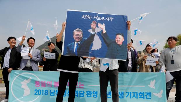 Students hold posters with pictures of South Korean President Moon Jae-in and North Korean leader Kim Jong Un during a pro-unification rally in Seoul on Thursday ahead of the upcoming summit between the North and South. Denuclearization to take center stage as Kim and Moon meet in rare inter-Korean summit