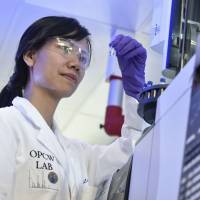 A laboratory technician looks at a test vial at the headquarters of The Organisation for the Prohibition of Chemical Weapons (OPCW) in the Hague Friday. Chemical weapons inspectors collect samples from alleged Syrian attack site