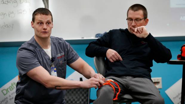 Trauma-care specialist Brian Feist (left) and Dr. Richard Sidwell lead a medical training session for teachers and staff at Southeast Polk High School in Pleasant Hill, Iowa, on March 28. U.S. teachers learn new skill: How to stop victims bleeding to death after being shot by school shooter