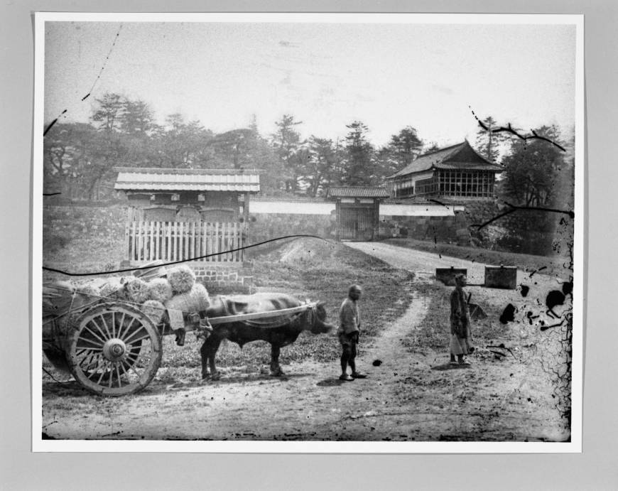 People with an ox cart walk in front of Edo Castle