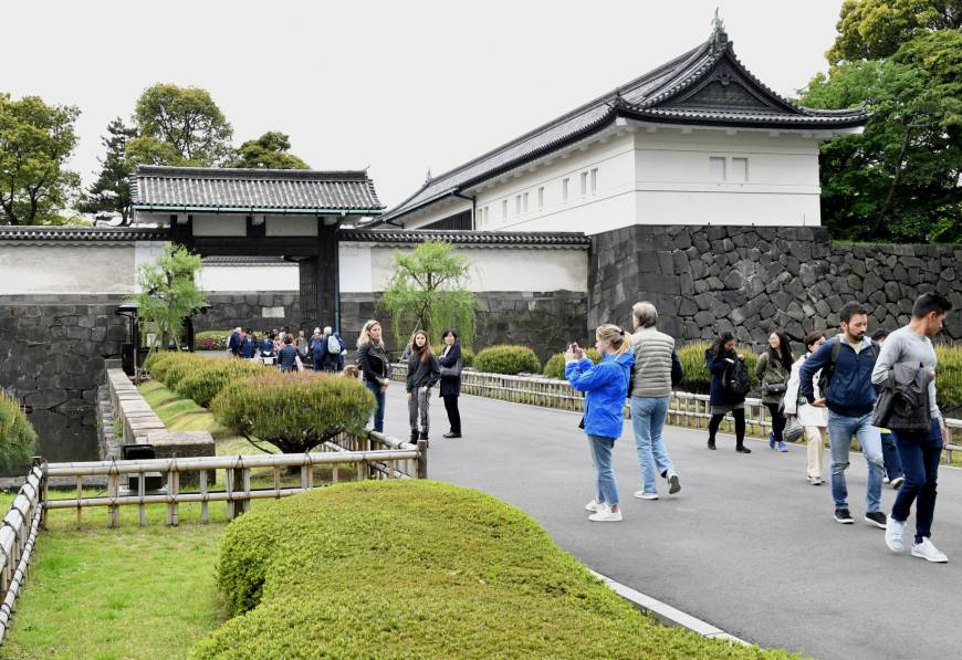 Tourists take photos in front of the Otemon gate at the Imperial Palace in April.