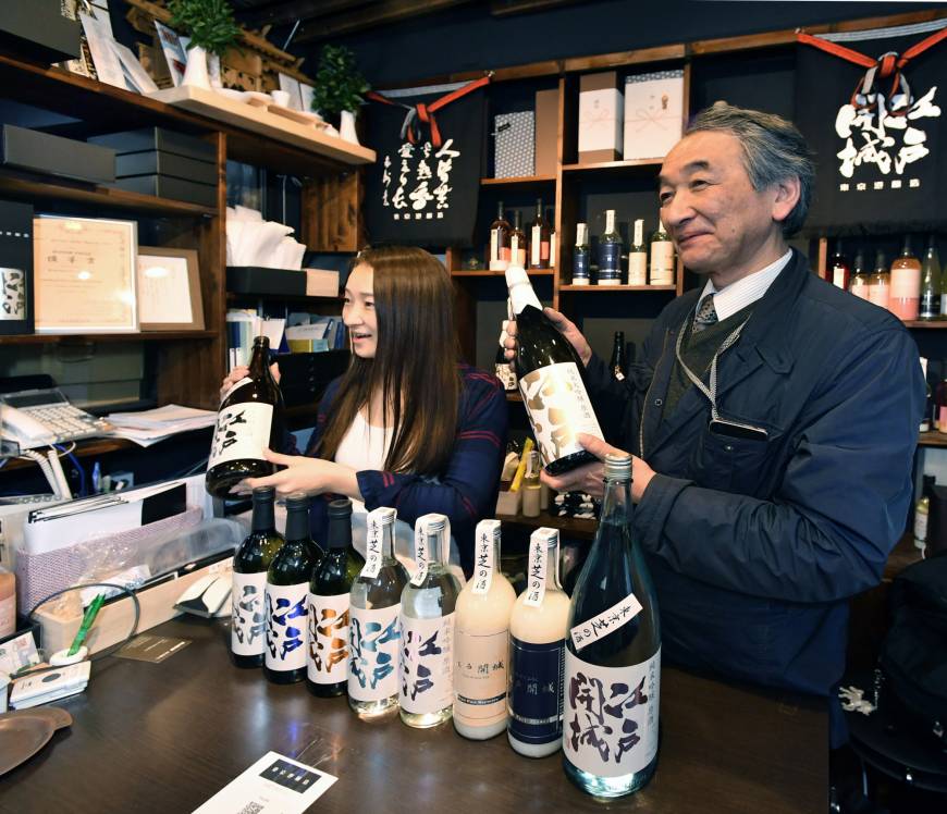 Shunichi Saito (right), president of Tokyo Port Brewery, which dates back to 1812, and his daughter, Kaede, show off the Edo Kaijo (Surrender of Edo Castle) sake brand in Minato Ward, Tokyo, on April 10.
