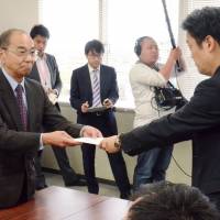 A Mie Prefectural Government official (right) on Thursday hands a license to cultivate cannabis for religious rituals to a member of a local association of Shinto shrines. Mie Prefecture shrine association gets license to grow cannabis for Shinto rituals