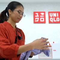 Cing, a refugee from Myanmar, works at a Uniqlo shop in Tokyo. Japan's short-handed firms turn to refugees for labor shortages