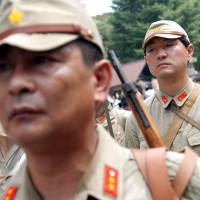 Japanese nationalists dressed in World War II-era uniforms of the defunct Imperial Japanese Army visit Yasukuni Shrine in Tokyo on Aug. 15, 2005, the 60th anniversary of the end of the war. China outlaws uploading of photos of people in Imperial Japanese Army costumes