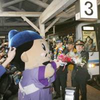 Railway workers receive flowers at a ceremony marking the last day of the Sanko Line at Gotsu Station in Shimane Prefecture on Saturday. The line was completed by West Japan Railway Co. (JR West) in 1975. JR West terminates Sanko Line linking Shimane and Hiroshima