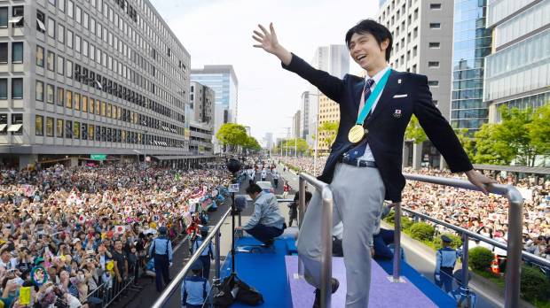 Two-time Olympic gold medalist Yuzuru Hanyu waves to the crowd during a victory parade on Sunday in Sendai. Huge hometown crowd celebrates Olympic figure skating champ Yuzuru Hanyu in Sendai