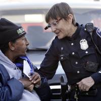 Seattle police officer Debra Pelich wears a video camera on her eyeglasses as she talks with Alex Legesse before a small community gathering in Seattle in 2015. While the Seattle Police Department bars officers from using real-time facial recognition in body camera video, privacy activists are concerned that a proliferation of the technology could turn the cameras into tools of mass surveillance. The ACLU and other organizations on Tuesday asked Amazon to stop selling its facial-recognition tool, called Rekognition, to law enforcement agencies. ACLU, other rights groups urge Amazon to not sell face-recognition tech to police