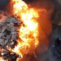 A giant mask depicting French President Emmanuel Macron is burned during a demonstration in Paris Tuesday. French public services workers have gone on strike as part of their protest of a government plan to cut 120,000 jobs by 2022. French public-sector workers join rail ranks in strike against Macron reforms