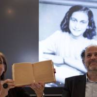 Teresien da Silva (left) and Ronald Leopold of the Anne Frank Foundation show a replica of Anne Frank’s diary with two pages taped off during a news conference at the foundation’s office in Amsterdam on Tuesday. 'An ordinary girl': Hidden pages in Anne Frank's diary reveal corny jokes and sex ed
