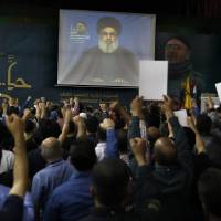 Hezbollah leader Sheik Hassan Nasrallah speaks on a screen via a video link during a ceremony to mark the second anniversary of the death of Hezbollah top commander, Mustafa Badreddine, who was killed in an explosion in Damascus, in the southern suburbs of Beirut Monday. Nasrallah said a barrage of rockets from Syria against Israeli forces in the occupied Golan Heights last week opens “a new phase” in the conflict, warning that Israel proper could be the target next time. Hezbollah says rocket salvo fired at Israeli-occupied Golan marks 'new phase' in Syria war