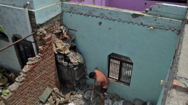 A man cleans a room littered with concrete after the walls and the roof of his house collapsed during a dust storm in Sewla village, in the northern Indian state of Uttar Pradesh, earlier this month. Nearly 50 people died overnight Monday as strong winds swept across northern India, blowing down mud-walled homes and uprooting trees, officials said Tuesday. As India temperatures in northern India near 50 C, 47 die in storms