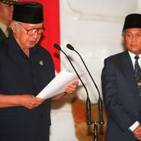 Indonesian President Suharto (left) announces his resignation at the presidential palace in Jakarta on May 21, 1998. Standing beside him is Vice President Jusuf Habibie. Indonesian parents wait for justice two decades after Suharto's fall