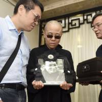Liu Xia, wife of jailed Nobel Peace Prize winner and Chinese dissident Liu Xiaobo, holds his portrait during his funeral in Shenyang, in northeastern China’s Liaoning Province, last July 15. China rejects appeal by foreign writers, artists on behalf of Nobel Prize winner Liu's widow
