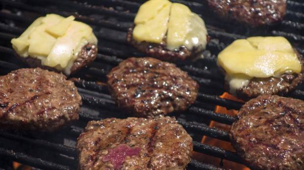 Organic hamburgers are grilled at an outdoor farmer’s market in Washington in this file photo. What are plant-based or vat-grown 'meats'? Industry debates