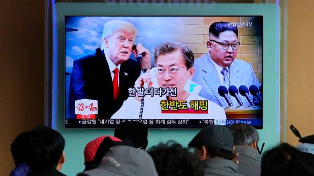 People watch a TV screen showing images of North Korean leader Kim Jong Un (right), South Korean President Moon Jae-in (center) and U.S. President Donald Trump at the main railway station in Seoul on March 7. Trump, Moon discuss North Korean threat to scrap landmark summit