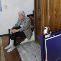 Yang Won-jin, 88, who spent 29 years in a South Korean prison before being released in 1988, sits near a newspaper showing North Korean leader Kim Jong Un and South Korean President Moon Jae-in, before an interview in Seoul on May 11. Elderly North Korean spies trapped in South yearn for home
