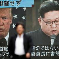 A pedestrian walks in front of a screen in Tokyo flashing a news report about U.S. President Donald Trump cancelling his meeting with North Korean leader Kim Jong Un. Trump says U.S. in 'productive talks' with North Korea, suggests summit with Kim could still happen on June 12