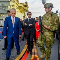 Australian Prime Minister Malcolm Turnbull and President of France Emmanuel Macron meet with military personnel on the HMAS Canberra at Garden Island in Sydney on Wednesday. France, Australia call on China to observe rules in South Pacific