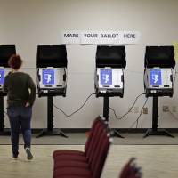 Kelly Monroe (left) an investigator with the Georgia secretary of state office, takes a look at a new voting machine being tested at a polling site in Conyers, Georgia, in October 2017. As EU privacy law looms, debate swirls on cybersecurity impact