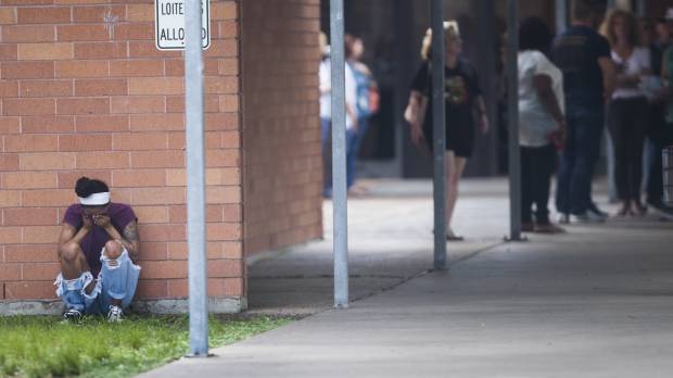 People gather by the Barnett Intermediate School, where parents went to pick up their children following a shooting at Santa Fe High School on Friday in Santa Fe, Texas. 'Do something': Parkland students express anger after Texas shooting