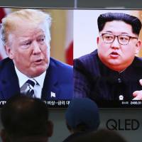 People watch a TV screen showing file footage of U.S. President Donald Trump and North Korean leader Kim Jong Un during a news program at the Seoul Railway Station in Seoul on Thursday. Trump-Kim summit preparation teams to focus on deal to ship North Korean nuclear warheads abroad