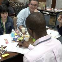 An asylum-seeker (center) talks about his experiences during a discussion in Shibuya Ward, Tokyo, on April 21, held by Welgee, a nonprofit organization that supports refugees in Japan. Japan's refugee-screening system sets high bar