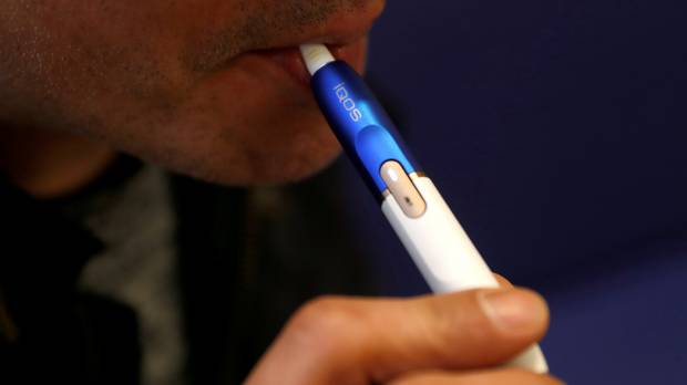 A man uses an iQOS e-cigarette. Phillip Morris' iQOS e-cigarette is capable of harvesting smoker's data: ex-project manager