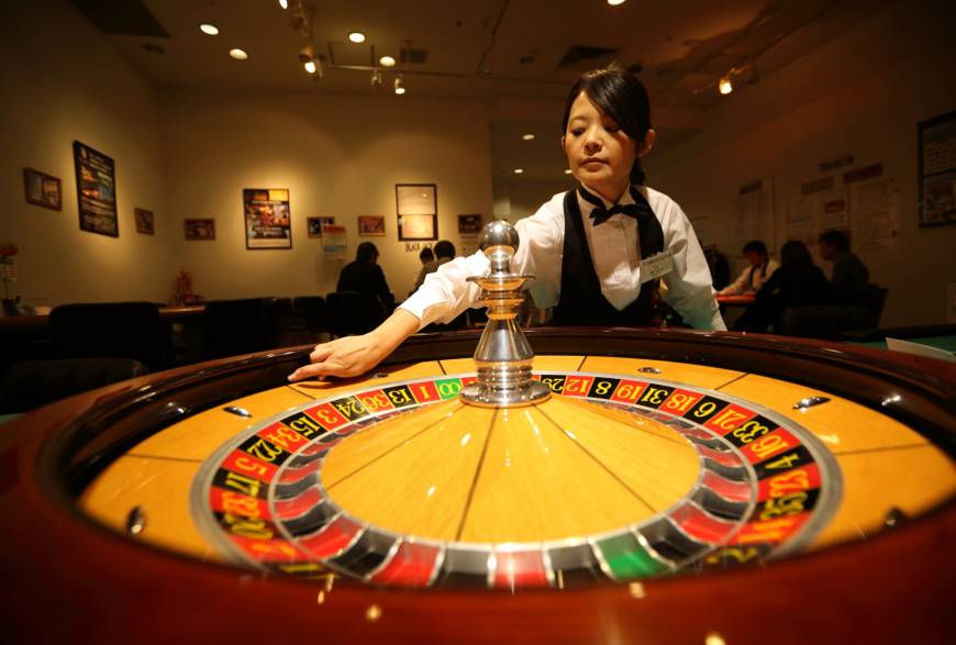 A woman spins a roulette wheel at a mock casino operated by Japan Casino School in Tokyo.