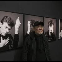 Iconic image: Masayoshi Sukita stands in front of the picture he took of David Bowie in 1977. The shot was used as the cover art for Bowie’s “Heroes” album. 'The Shoot Must Go On': Masayoshi Sukita captures some of rock music's most iconic figures