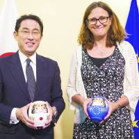 Then-Foreign Minister Fumio Kishida (left) and European Commissioner for Trade Cecilia Malmstroem pose with daruma dolls after reaching a consensus on a bilateral economic partnership agreement in Brussels on July 5. | EUROPEAN UNIONE
