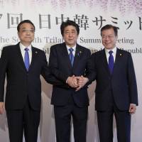 Chinese Premier Li Keqiang ( left), Prime Minister Shinzo Abe and South Korean President Moon Jae-in pose for photographers prior to their summit in Tokyo on May 9. Japan's foreign policy balancing act