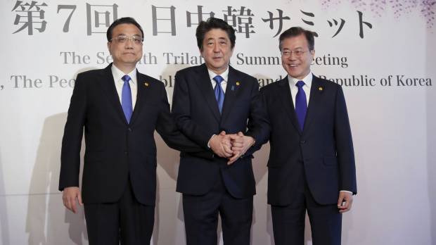 Chinese Premier Li Keqiang ( left), Prime Minister Shinzo Abe and South Korean President Moon Jae-in pose for photographers prior to their summit in Tokyo on May 9. Japan's foreign policy balancing act