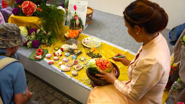 Fruits of Thailand: A participant at a Thai Festival in Yoyogi Park carves a melon at her stall. Cultural education can be fun for kids