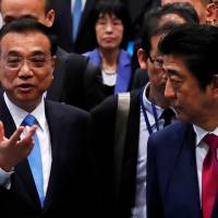 Chinese Premier Li Keqiang talks to Prime Minister Shinzo Abe during a visit to a plant of Toyota Motor Hokkaido Inc. in Tomakomai, Hokkaido, on May 11. China moving slowly into Hokkaido