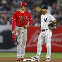 Los Angeles designated hitter Shohei Ohtani talks with New York second baseman Gleyber Torres during the fourth inning on Friday night. Ohtani hitless in loss to Yanks